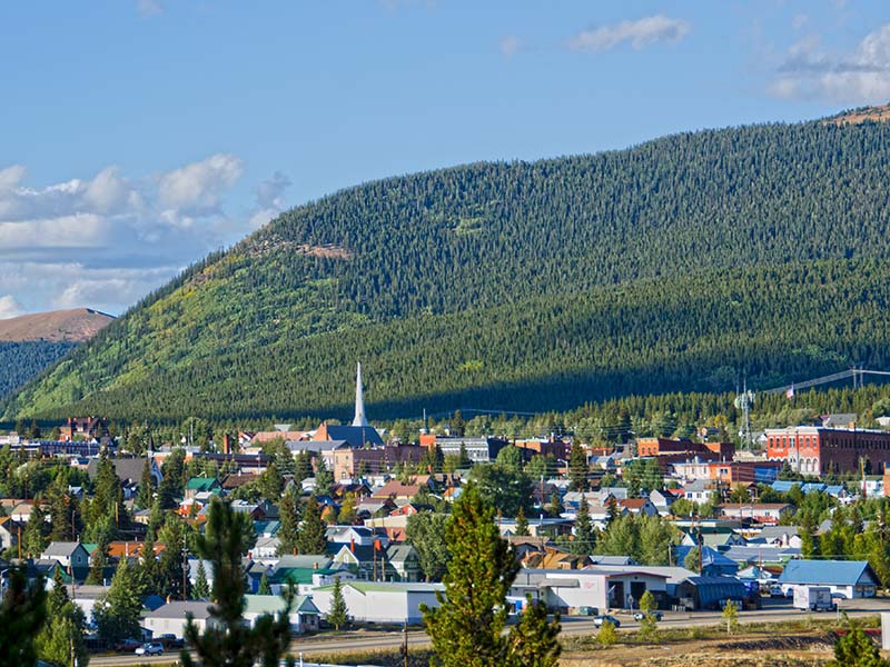 Una pequeña ciudad enclavada en montañas boscosas.